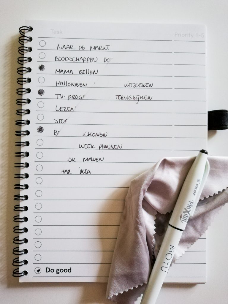 duurzaam notitieboekje beschreven bladzijde met een To Do lijst die voor een deel is uitgewist. Doekje en pen. 